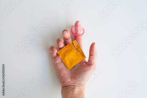 Condom in hand on a white background. Concept of health protection during sex.