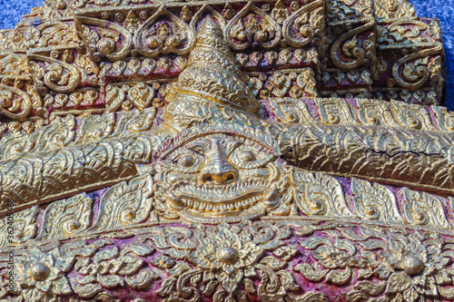 Beautiful sun-shaped human faces carving on the wall of the pagoda in the Buddhist temple, Chiang Mai, Thailand. © kampwit