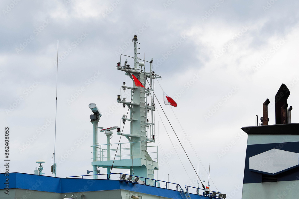 Naklejka premium nearby is a blue-and-white transport ship with the white-and-red flag of Poland . the wheelhouse steering the vessel