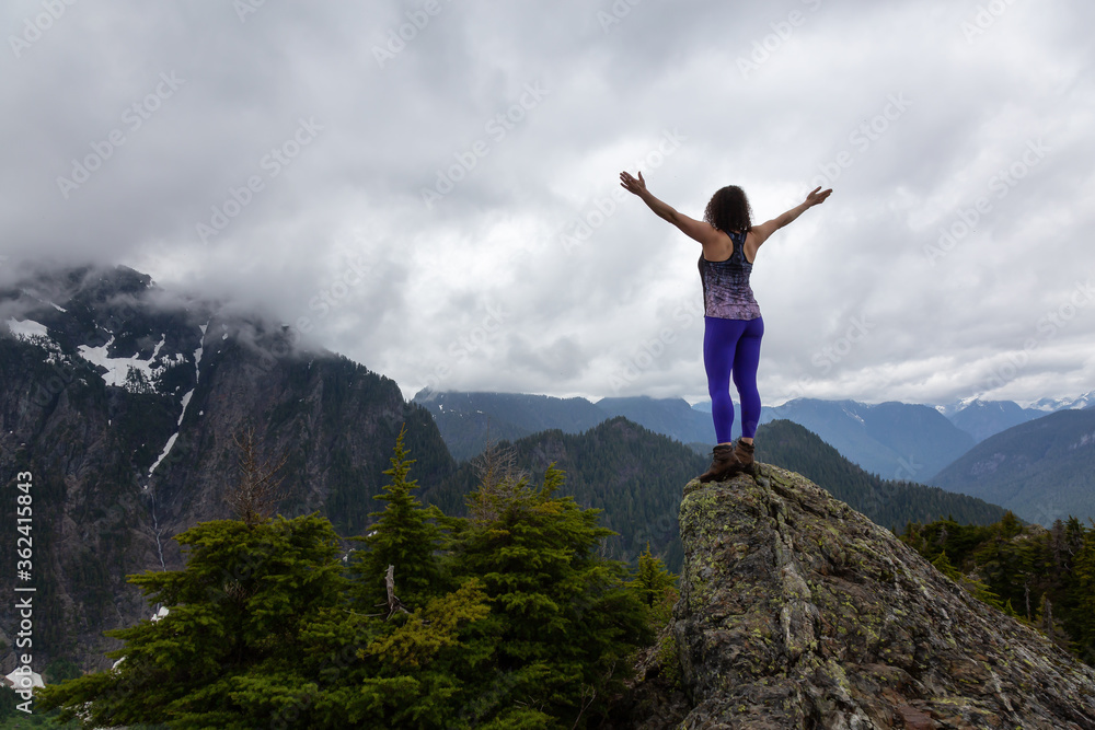 Adventurous Girl on top of a Mountain top with Canadian Nature Landscape in Background. Taken on Evan's Peak, Golden Ears Provincial Park, near Vancouver, BC, Canada. Adventurous Girl on top of a Mountain top with Canadian Nature Landscape in Background. Taken on Evan's Peak, Golden Ears Provincial Park, near Vancouver, BC, Canada.