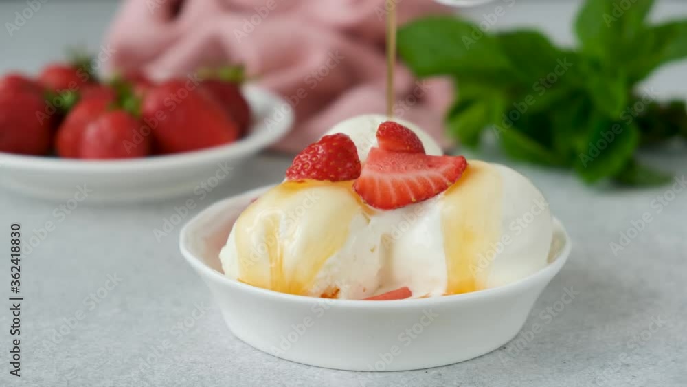 Vanilla ice cream with syrup. Lemon syrup pouring on vanilla ice cream scoops. Serving summer dessert ice cream in bowl Vanilla ice cream with syrup. Lemon syrup pouring on vanilla ice cream scoops. Serving summer dessert ice cream in bowl