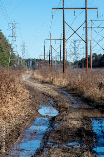 Muddy dirt utility access road winding through high tension wires photo