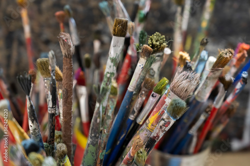 A lot dirty artist paint brushes in a bucket