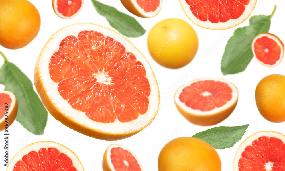 Levitation of whole grapefruit and slices on a white background with selective focus. Banner, wallpaper, advertising. Levitation of whole grapefruit and slices on a white background with selective focus. Banner, wallpaper, advertising.