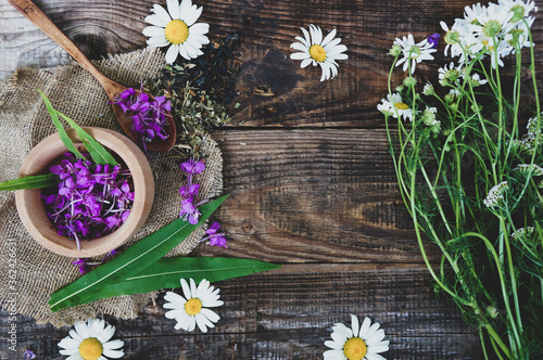 flowers and leaves of ivan chamomile tea on a wooden rustic table, Epilobium angustifolium. Fireweed (Rosebay Willowherb), pink flowers in a wooden spoon, healing herbs, copy space