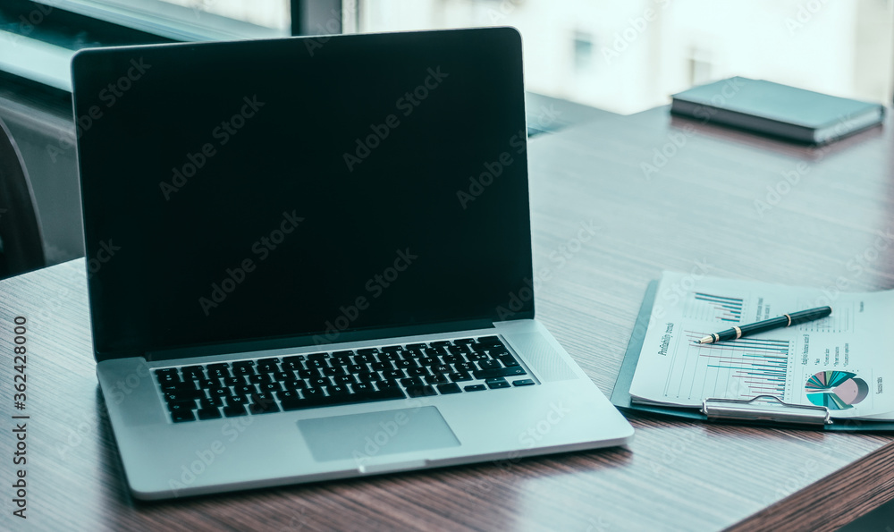 close up. a laptop computer and financial graph on the desktop. close up. a laptop computer and financial graph on the desktop.