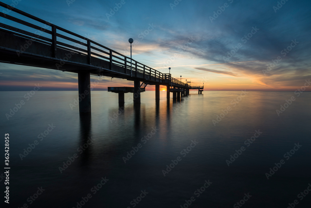 sunset with pier on the baltic sea