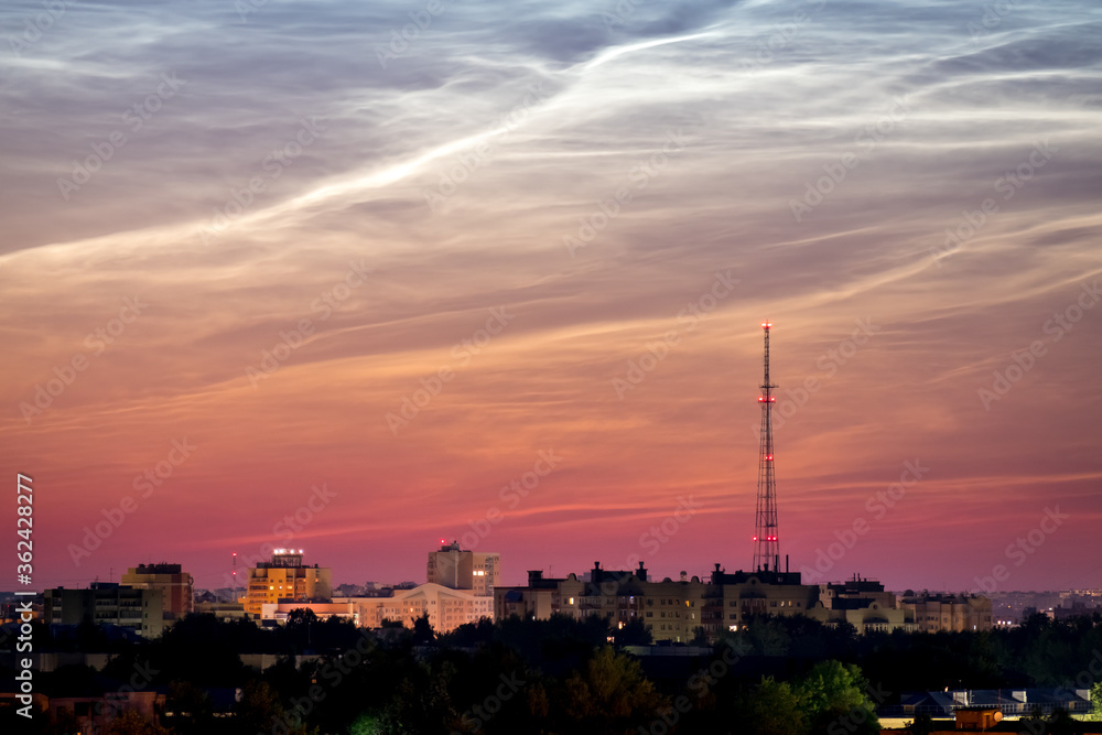 Dawn Cityscape. Beautiful sky and clouds, night illumination of houses, silhouette of a telephone tower. Vladimir city, Russia
