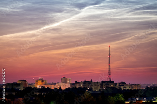Dawn Cityscape. Beautiful sky and clouds, night illumination of houses, silhouette of a telephone tower. Vladimir city, Russia