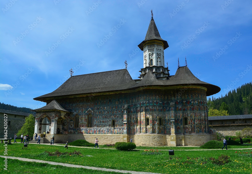 Fototapeta premium SUCEVITE MONASTERY, BUCOVINA, ROMANIA, EUROPE, SPRING 2018. Orthodox monastery. Moldovan architectural style. Open-air paintings, frescoes and portraits of saints with Byzantine influence.