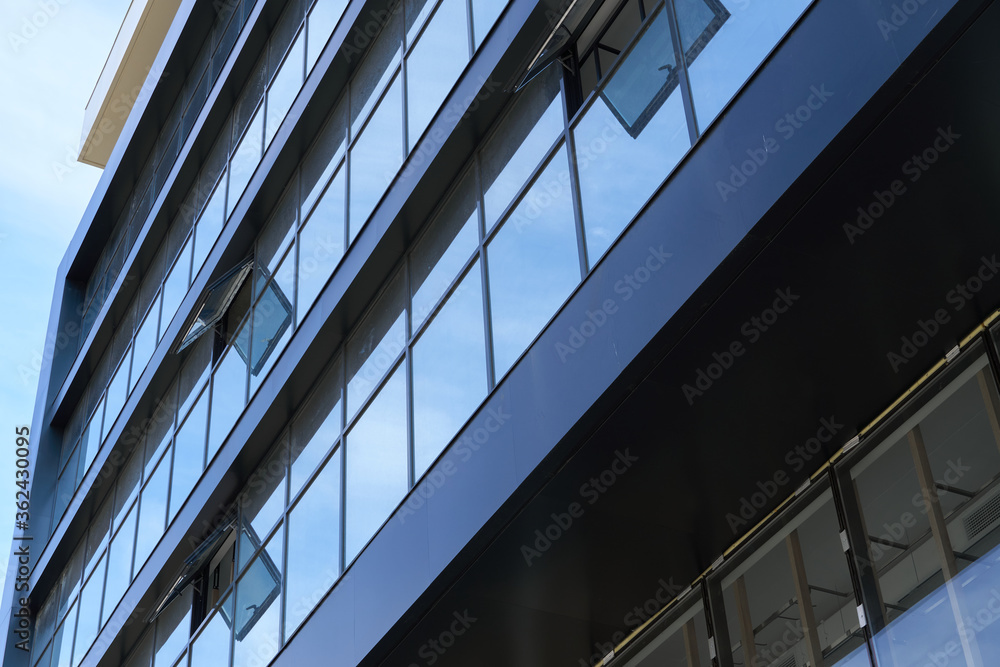 facade of a modern building on a bright Sunny day, blue sky and clouds reflecting in a glass, beautiful exterior of the new building facade of a modern building on a bright Sunny day, blue sky and clouds reflecting in a glass, beautiful exterior of the new building