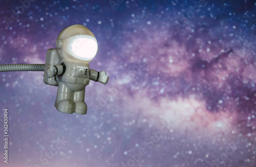 Little toy astronaut traveling through space  with a background of the Milky Way and the Galactic Center