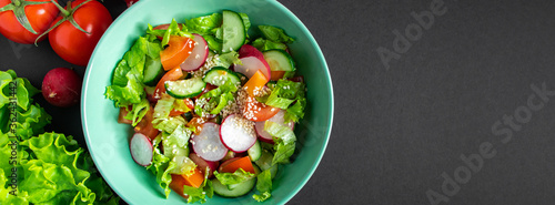 Seasonal vegetable salad from organic farm products on gray background. Mix of tomatoes  cucumbers and radishes.