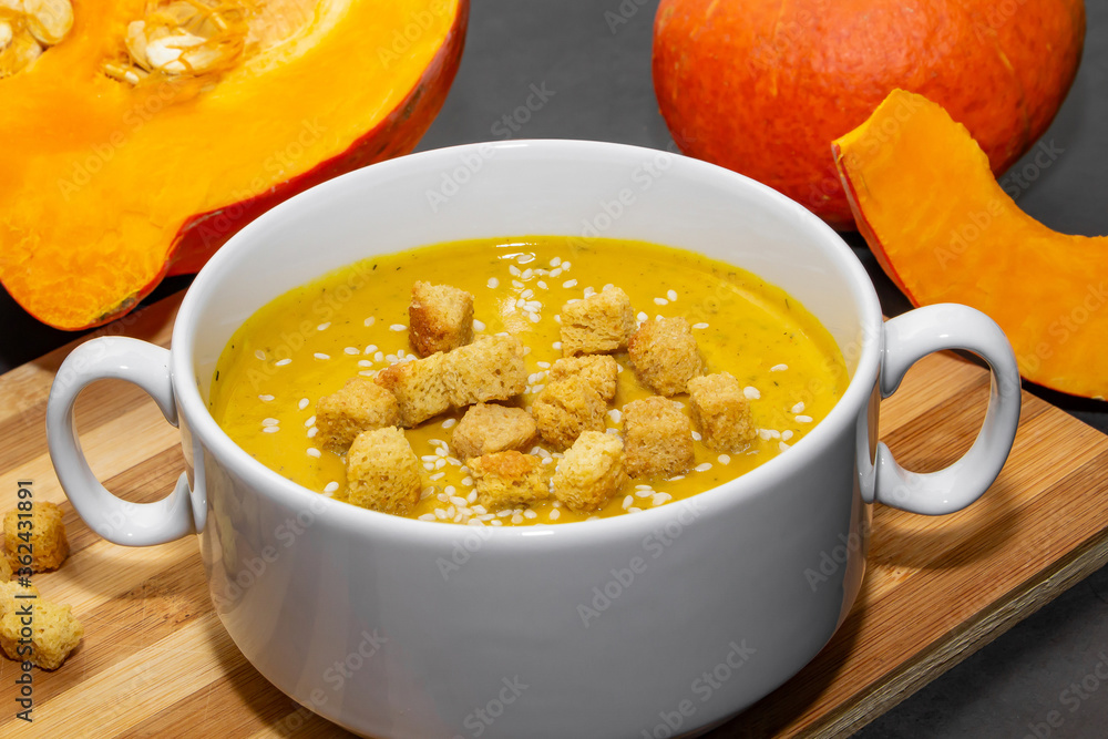 Autumn pumpkin soup with sesame seeds on a wooden background Autumn pumpkin soup with sesame seeds on a wooden background