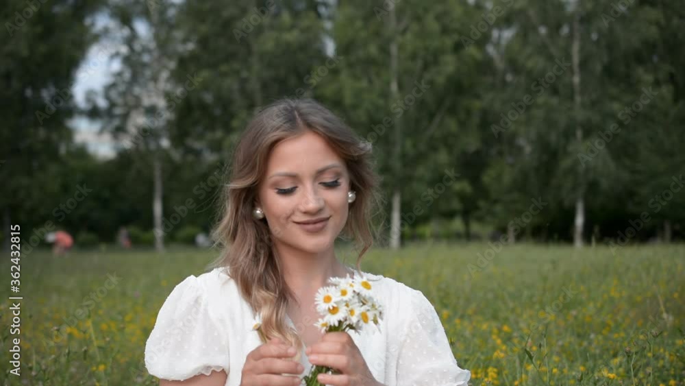 Portrait of a beautiful girl with a small bouquet of daisies in her hands outdoor Portrait of a beautiful girl with a small bouquet of daisies in her hands outdoor