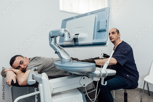 Doctor performing an ultrasound scan on a patient lying on a stretcher