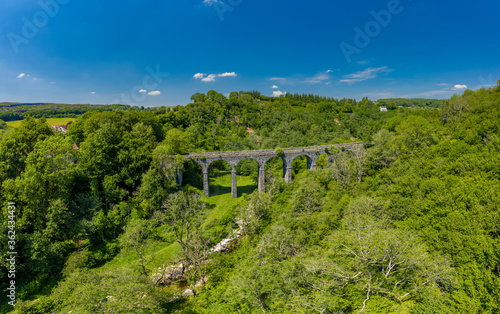 Aerial drone view of a Victorian era viaduct in a beautiful green valley (Pontsarn Viaduct, Brecon Beacons, Wales)
