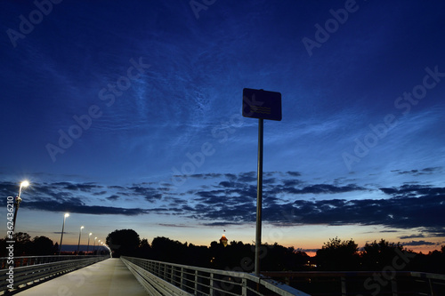 Silvery clouds above the bridge with glowing led lamps.