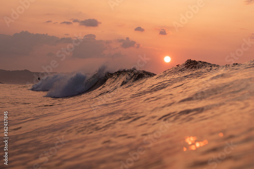 Sunrise in Japan while swimming in the Ocean amongst the waves on the Pacific coast line close to Tokyo city. The sky is stunning & shows why its called the Land of the rising sun. photo