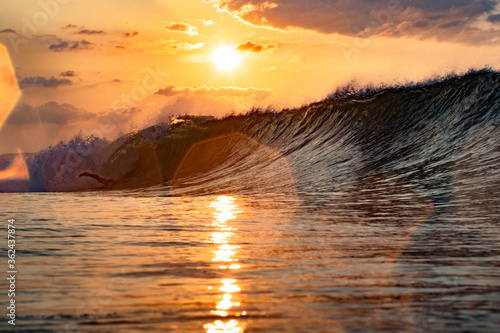 Sunrise in Japan while swimming in the Ocean amongst the waves on the Pacific coast line close to Tokyo city. The sky is stunning & shows why its called the Land of the rising sun. photo