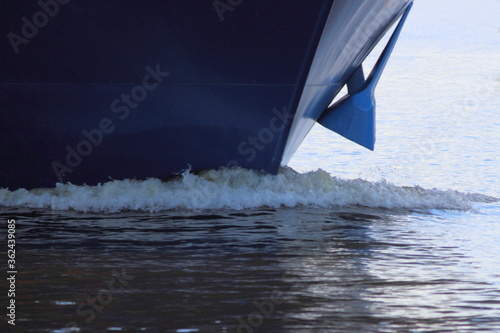 Bow keel wave and shipboard with anchor of blue passenger liner cruise ship closeup front view on summer day - boat travel vacation,  tourism photo