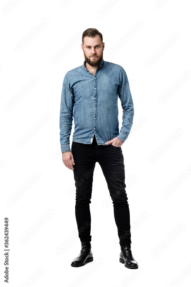 Picture of a bearded Caucasian male looking serious while looking towards the camera with one hand in his pocket wearing a blue long sleeves shirt. Picture of a bearded Caucasian male looking serious while looking towards the camera with one hand in his pocket wearing a blue long sleeves shirt.