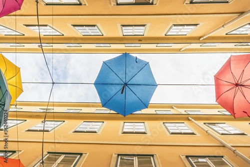 Photography Colorful umbrellas hanging out above old passage street in Vienna