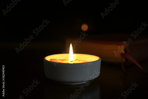 Candlelight with holy bible at the background.