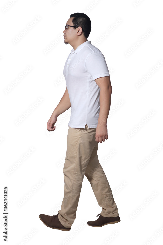 Full length portrait of Asian man wearing white shirt and khaki jeans standing walking, side view profile Full length portrait of Asian man wearing white shirt and khaki jeans standing walking, side view profile