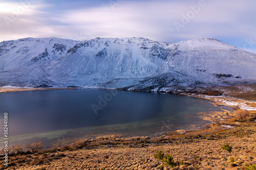 Long exposure shot of a mountain lake against snow-capped mountains during the sunset in winter, Esquel, Patagonia, Argentina