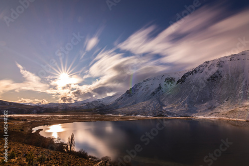 Landscape view against sun and snowcapped Andes mountains in Willimanco Lagoon, Esquel, Patagonia, Argentina