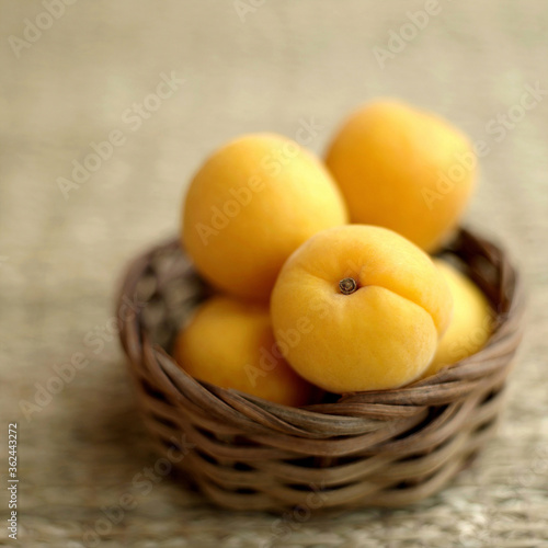 Close up of some apricots in a woven container