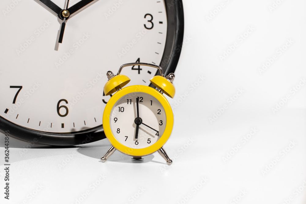 Small orange analog clock with big clock concept time passing faster Small orange analog clock with big clock concept time passing faster