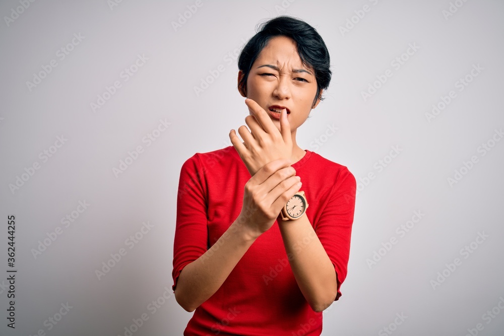 Young beautiful asian girl wearing casual red t-shirt standing over isolated white background Suffering pain on hands and fingers, arthritis inflammation Young beautiful asian girl wearing casual red t-shirt standing over isolated white background Suffering pain on hands and fingers, arthritis inflammation
