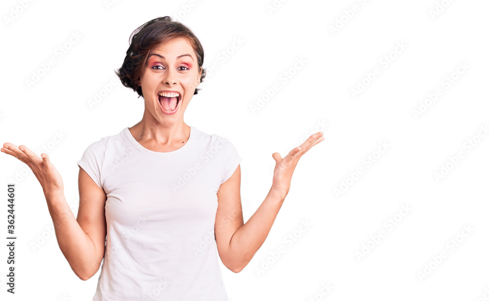 Beautiful young woman with short hair wearing casual clothes celebrating victory with happy smile and winner expression with raised hands Beautiful young woman with short hair wearing casual clothes celebrating victory with happy smile and winner expression with raised hands