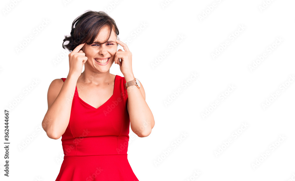 Beautiful young woman with short hair wearing casual style with sleeveless shirt covering ears with fingers with annoyed expression for the noise of loud music. deaf concept. Beautiful young woman with short hair wearing casual style with sleeveless shirt covering ears with fingers with annoyed expression for the noise of loud music. deaf concept.