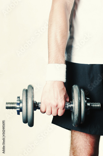 A muscular right hand holding a dumbbell