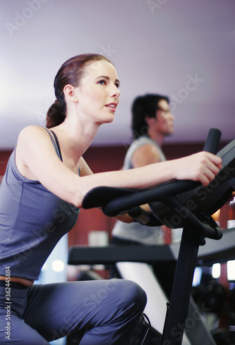 A lady and her boyfriend exercising in a gymnasium