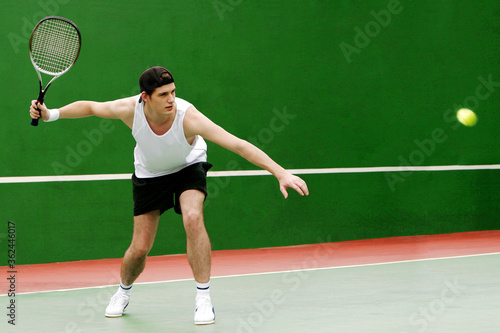 A man playing tennis in the tennis court © ImageHit