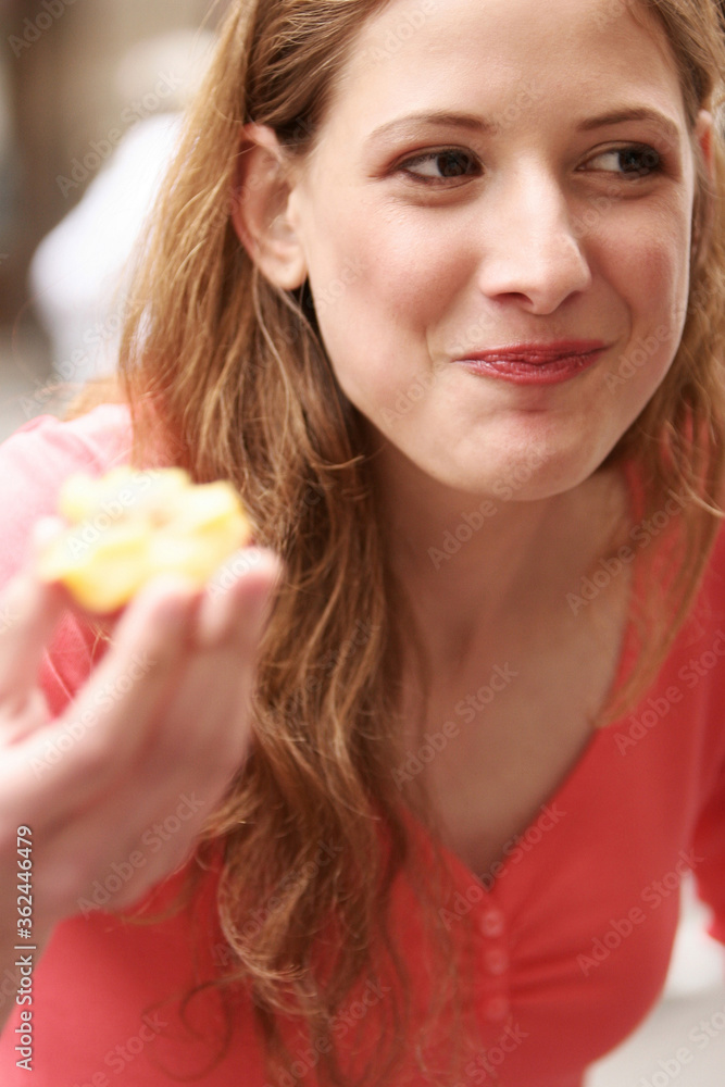 A lady smiling while eating a biscuit A lady smiling while eating a biscuit