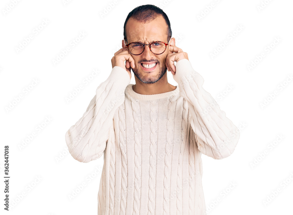 Young handsome man wearing casual clothes and glasses covering ears with fingers with annoyed expression for the noise of loud music. deaf concept. Young handsome man wearing casual clothes and glasses covering ears with fingers with annoyed expression for the noise of loud music. deaf concept.