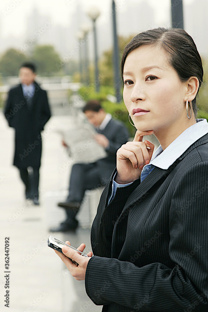 A lady in business suit holding palmtop thinking A lady in business suit holding palmtop thinking