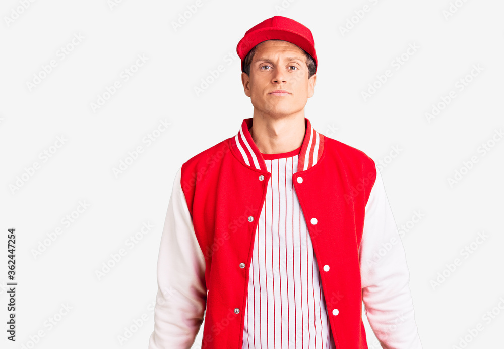 Young handsome man wearing baseball uniform with serious expression on face. simple and natural looking at the camera. Young handsome man wearing baseball uniform with serious expression on face. simple and natural looking at the camera.