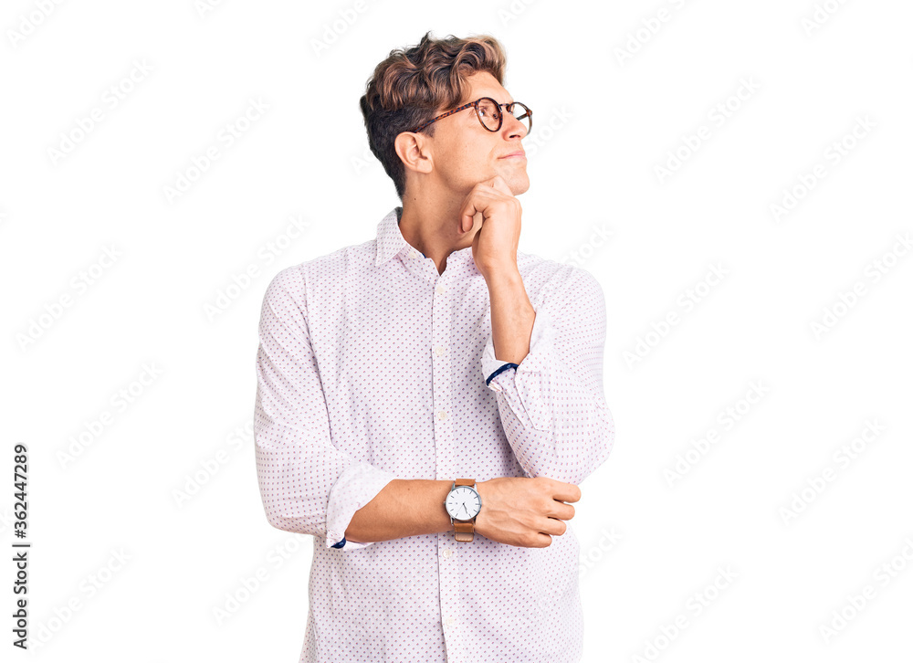 Young handsome man wearing business clothes and glasses with hand on chin thinking about question, pensive expression. smiling with thoughtful face. doubt concept. Young handsome man wearing business clothes and glasses with hand on chin thinking about question, pensive expression. smiling with thoughtful face. doubt concept.