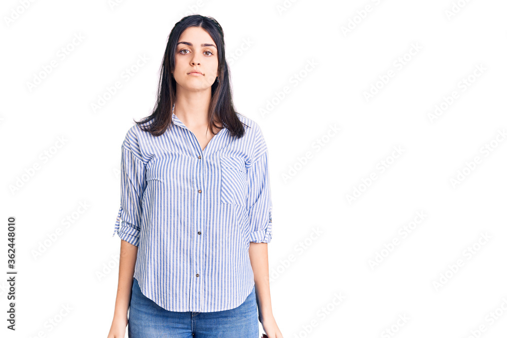 Young beautiful girl wearing striped shirt with serious expression on face. simple and natural looking at the camera. Young beautiful girl wearing striped shirt with serious expression on face. simple and natural looking at the camera.