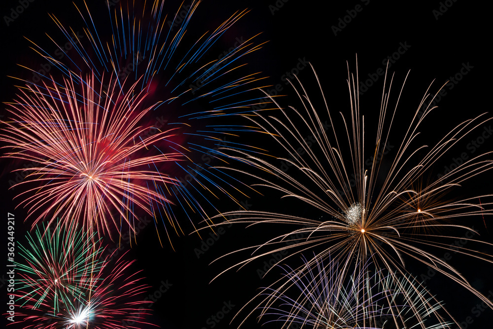 Obraz premium A very large and colorful firework explodes in the night sky in a celebration of freedom on the Fourth of July.