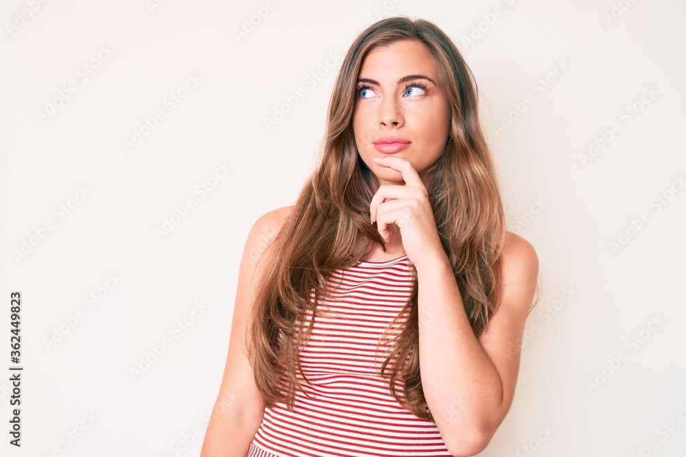 Beautiful young caucasian woman wearing casual clothes serious face thinking about question with hand on chin, thoughtful about confusing idea