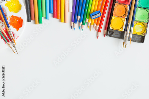 Top view of Colorful Watercolor palette, paintbrush, colored pencils, ruler and drawing equipment  on white background and copy space