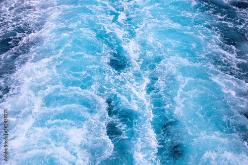 Motor boat tail splashing sea water. White foam on blue water. Ocean transportation. Tropical island hopping