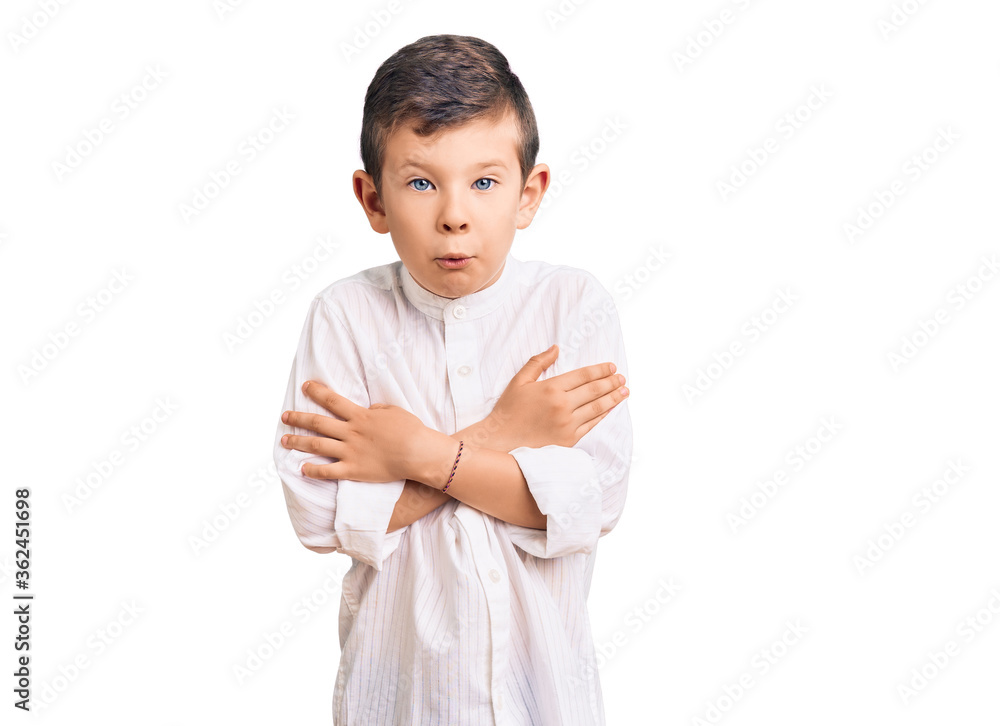 Cute blond kid wearing elegant shirt shaking and freezing for winter cold with sad and shock expression on face